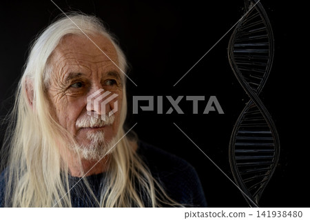 Long haired gray haired man is looking at a DNA structure on a black background. Long haired gray haired man is looking at a DNA structure on a black background. 141938480