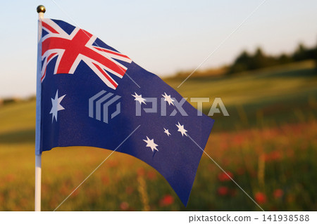 Australian flag waving against sunset field sky Australian flag waving against sunset field sky 141938588