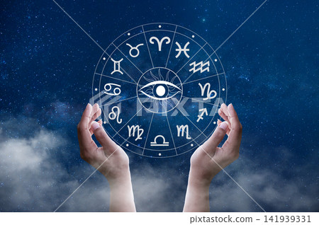 Cupped hands holding an astrology zodiac wheel with all seeing eye, under a starry Milky Way sky. Cupped hands holding an astrology zodiac wheel with all seeing eye, under a starry Milky Way sky. 141939331
