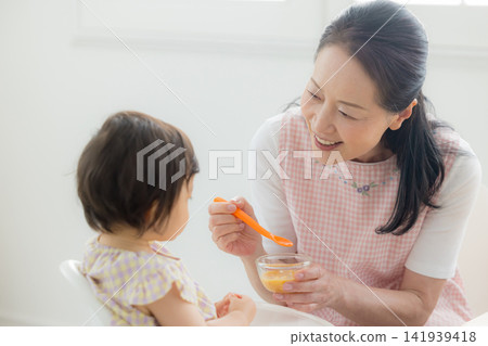 一個一歲女嬰在吃嬰兒食品 一個一歲女嬰在吃嬰兒食品 141939418