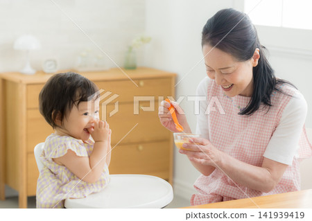 A one-year-old girl eating baby food A one-year-old girl eating baby food 141939419