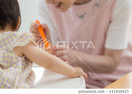 一個一歲女嬰在吃嬰兒食品 一個一歲女嬰在吃嬰兒食品 141939425