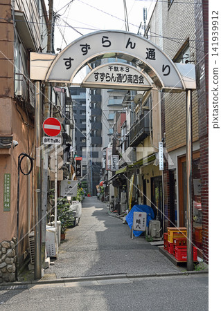 市中心商業街的拱門;柔和的午後陽光照亮了谷中、根津和千駄木的復古街道。 市中心商業街的拱門;柔和的午後陽光照亮了谷中、根津和千駄木的復古街道。 141939912