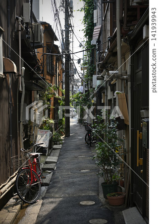 The shadows of the old town permeate the back alleys; the red bicycle and the dappled lettering in the trees create a beautiful scene of everyday life in Yanaka, Nezu, and Sendagi. The shadows of the old town permeate the back alleys; the red bicycle and the dappled lettering in the trees create a beautiful scene of everyday life in Yanaka, Nezu, and Sendagi. 141939943