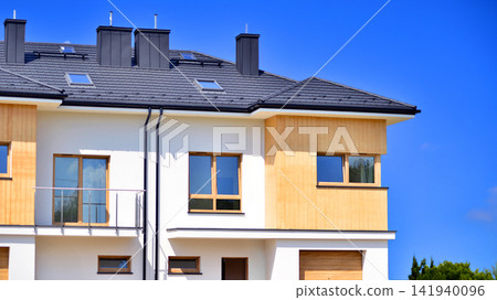 New single family houses in a new development area. Residential homes with modern facade. The real estate market in the suburbs. Terraced family homes in newly developed housing estate. New single family houses in a new development area. Residential homes with modern facade. The real estate market in the suburbs. Terraced family homes in newly developed housing estate. 141940096