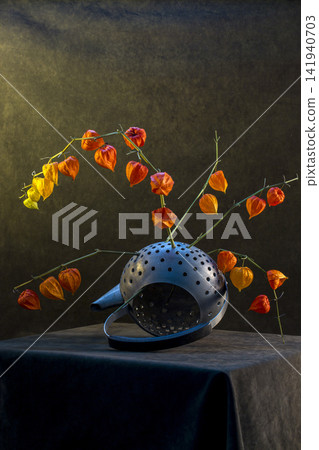 Physalis plant branches in a teapot with drilled holes Physalis plant branches in a teapot with drilled holes 141940703