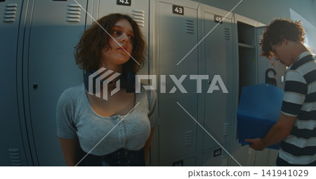 Creative Teen Girl Lost in Thoughts With Calm, Slightly Distant Gaze in School Locker Room Creative Teen Girl Lost in Thoughts With Calm, Slightly Distant Gaze in School Locker Room 141941029