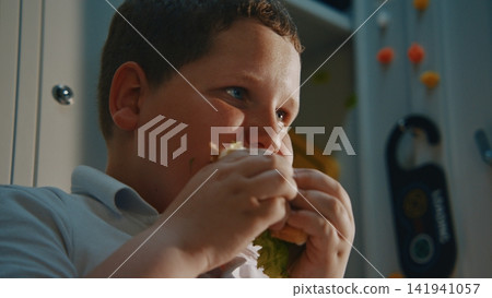 Young Student Relaxing Beside Metal Locker with Homemade Lunch During Recess Young Student Relaxing Beside Metal Locker with Homemade Lunch During Recess 141941057