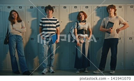 Trendy Teenage Students with Gadgets and Books Standing in Hallway Trendy Teenage Students with Gadgets and Books Standing in Hallway 141941070