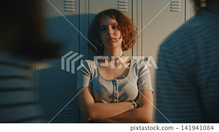 Anxious Teen Female Student Feeling Distressed inside School Locker Room Anxious Teen Female Student Feeling Distressed inside School Locker Room 141941084