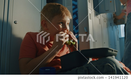 Young Schoolboy Having Lunch with Reusable Food Container and Insulated Bottle Nearby Young Schoolboy Having Lunch with Reusable Food Container and Insulated Bottle Nearby 141941120