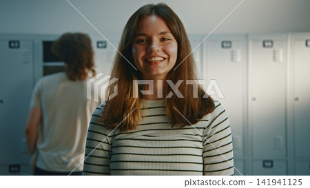 Friendly and Communicative Young Girl Standing Next to Lockers Friendly and Communicative Young Girl Standing Next to Lockers 141941125