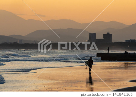 湘南久根沼海灘,衝浪者沿著海岸線行走的剪影。 湘南久根沼海灘,衝浪者沿著海岸線行走的剪影。 141941165