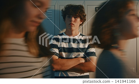 Teen Boy Watching Students Walk Through School Hallway Teen Boy Watching Students Walk Through School Hallway 141941166