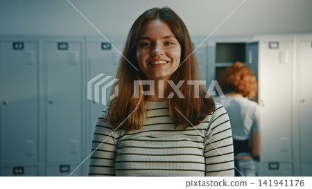 Friendly and Communicative Young Girl Standing Next to Lockers 141941176