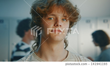 Calm Young Male Student Standing by Lockers on Campus Calm Young Male Student Standing by Lockers on Campus 141941193