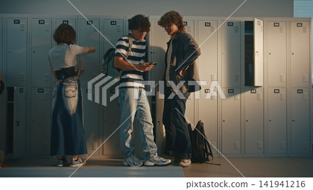 Teenagers Chatting, Sharing Thoughts and Interacting in School Corridor by Lockers Teenagers Chatting, Sharing Thoughts and Interacting in School Corridor by Lockers 141941216