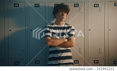Worried Teenage Student Standing Alone Near School Lockers Worried Teenage Student Standing Alone Near School Lockers 141941221
