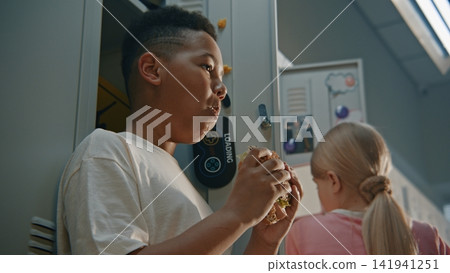 Elementary School Boy Takes Quick Bite of Packed Homemade Sandwich Elementary School Boy Takes Quick Bite of Packed Homemade Sandwich 141941251
