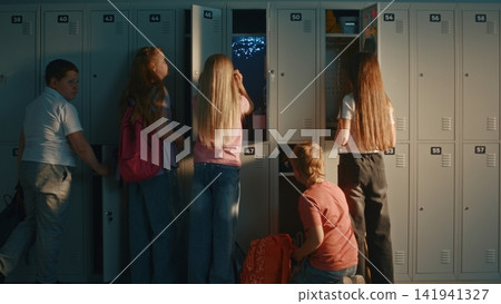 Group Of Diverse School Children Interacting With Lockers in Sunny School Hallway. 141941327