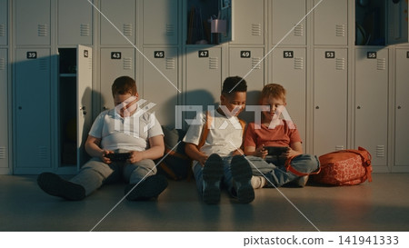 Primary School Students Using Handheld Digital Devices During School Break Primary School Students Using Handheld Digital Devices During School Break 141941333