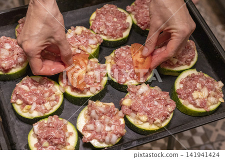 Putting Baking Sheet of Stuffed Zucchini Rounds Inside the Oven Putting Baking Sheet of Stuffed Zucchini Rounds Inside the Oven 141941424