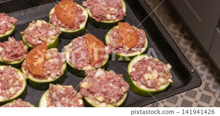 Putting Baking Sheet of Stuffed Zucchini Rounds Inside the Oven Putting Baking Sheet of Stuffed Zucchini Rounds Inside the Oven 141941426