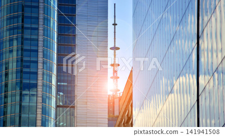 A modern tall building made of steel and glass, housing offices and financial institutions. Glass wall on the facade of the building. A modern tall building made of steel and glass, housing offices and financial institutions. Glass wall on the facade of the building. 141941508