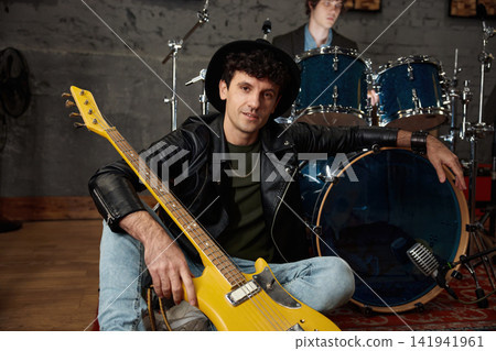 Relaxed musicians gear up for concert in authentic urban rehearsal space Relaxed musicians gear up for concert in authentic urban rehearsal space 141941961