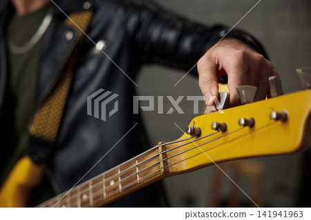 Adjusting headstock before setup. Tuning bass guitar headstock manually Adjusting headstock before setup. Tuning bass guitar headstock manually 141941963