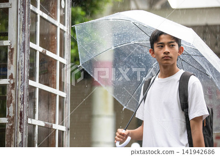 Male students waiting in the rain Male students waiting in the rain 141942686