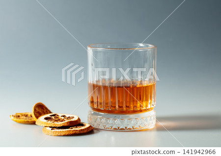 Whiskey in crystal glass with dried orange slices. Whiskey in crystal glass with dried orange slices. 141942966