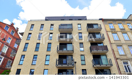 Modern apartment buildings on a sunny day with a blue sky. Facade of a modern apartment building.Glass surface with sunlight. 141943301