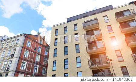Modern apartment buildings on a sunny day with a blue sky. Facade of a modern apartment building.Glass surface with sunlight. Modern apartment buildings on a sunny day with a blue sky. Facade of a modern apartment building.Glass surface with sunlight. 141943302