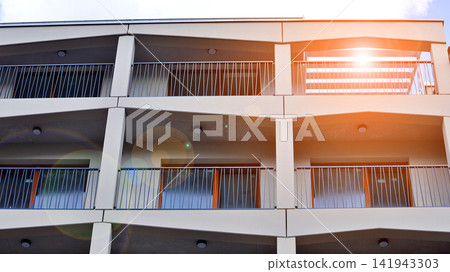 Modern apartment buildings on a sunny day with a blue sky. Facade of a modern apartment building.Glass surface with sunlight. Modern apartment buildings on a sunny day with a blue sky. Facade of a modern apartment building.Glass surface with sunlight. 141943303