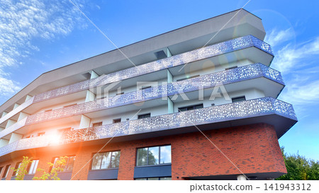 Modern apartment buildings on a sunny day with a blue sky. Facade of a modern apartment building.Glass surface with sunlight. Modern apartment buildings on a sunny day with a blue sky. Facade of a modern apartment building.Glass surface with sunlight. 141943312