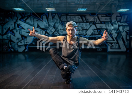 Expressive hip hop dancer posing with hand near cap Expressive hip hop dancer posing with hand near cap 141943753