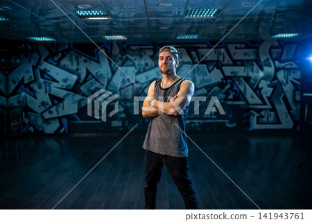 Bearded man standing with crossed arms inside dance studio Bearded man standing with crossed arms inside dance studio 141943761