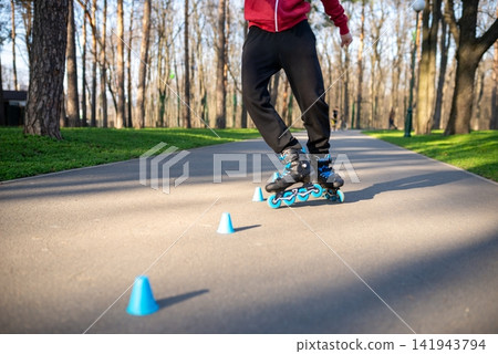 Skater performing an advanced inline slalom trick at sunset Skater performing an advanced inline slalom trick at sunset 141943794