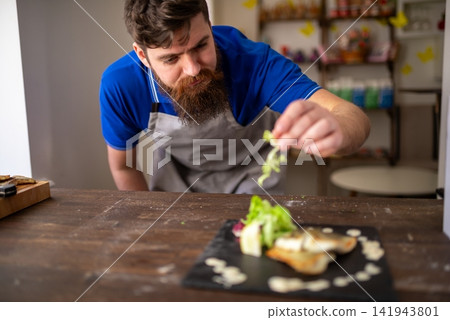 Garnish being added to a plated fish dish by a chef Garnish being added to a plated fish dish by a chef 141943801