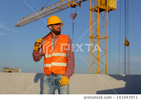 Construction manager and engineer discussing building project on site with crane in background Construction manager and engineer discussing building project on site with crane in background 141943951