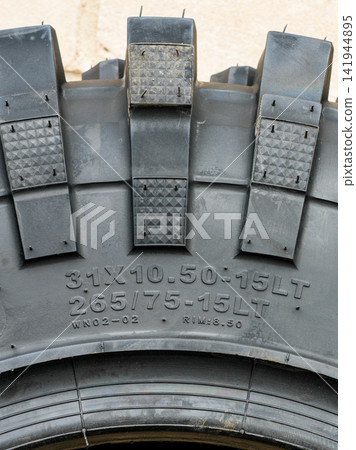 Off-Road Tire Size Markings in Metric and Inch Systems with Large Heavy-Duty Tread Blocks Close-Up Off-Road Tire Size Markings in Metric and Inch Systems with Large Heavy-Duty Tread Blocks Close-Up 141944895