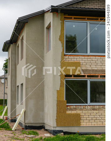 House Facade Renovation with Mineral Wool Insulation and Exterior Plaster During Energy Upgrade Work House Facade Renovation with Mineral Wool Insulation and Exterior Plaster During Energy Upgrade Work 141944899