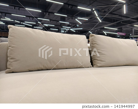 A cozy gray couch with oversized, elongated cushions, available in the furniture department of a hypermarket A cozy gray couch with oversized, elongated cushions, available in the furniture department of a hypermarket 141944997