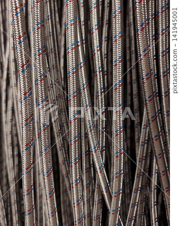 Reinforced metal braided hoses for water supply systems displayed on hardware store rack with plumbing products Reinforced metal braided hoses for water supply systems displayed on hardware store rack with plumbing products 141945001