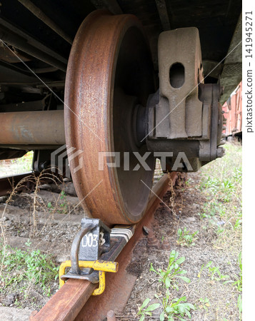 Railroad brake chock supporting stationary steel wheel of heavy freight train Railroad brake chock supporting stationary steel wheel of heavy freight train 141945271