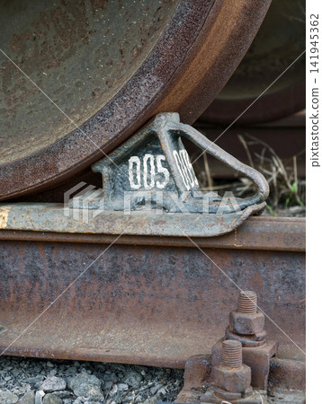 Cargo train wheel resting securely on brake chock preventing movement along railway lines Cargo train wheel resting securely on brake chock preventing movement along railway lines 141945362