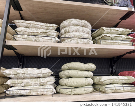 Chair cushions arranged on supermarket shelves with soft padded seat pads and home comfort textile assortment detail Chair cushions arranged on supermarket shelves with soft padded seat pads and home comfort textile assortment detail 141945381
