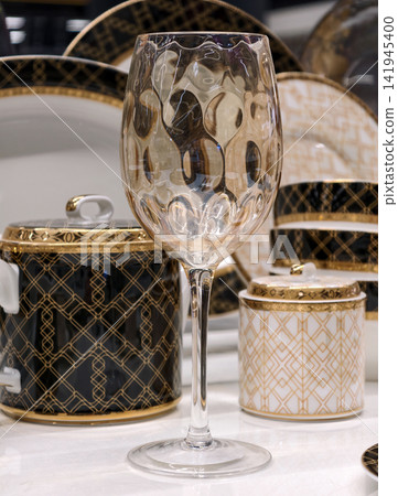Refined crystal glass placed elegantly on a luxury table with sophisticated dining details softly visible behind Refined crystal glass placed elegantly on a luxury table with sophisticated dining details softly visible behind 141945400