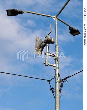 A loud air raid siren on a public street, warning civilians about incoming missile strikes or aerial bombing raids A loud air raid siren on a public street, warning civilians about incoming missile strikes or aerial bombing raids 141945409